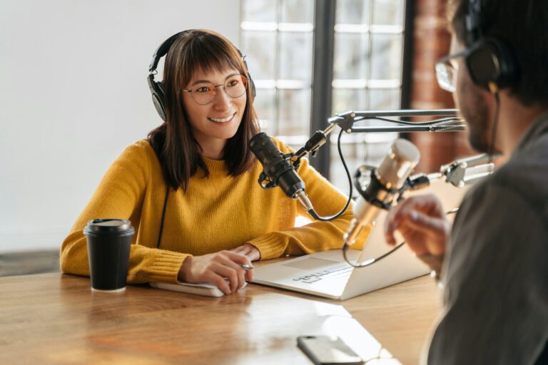 Two podcasters recording in a studio