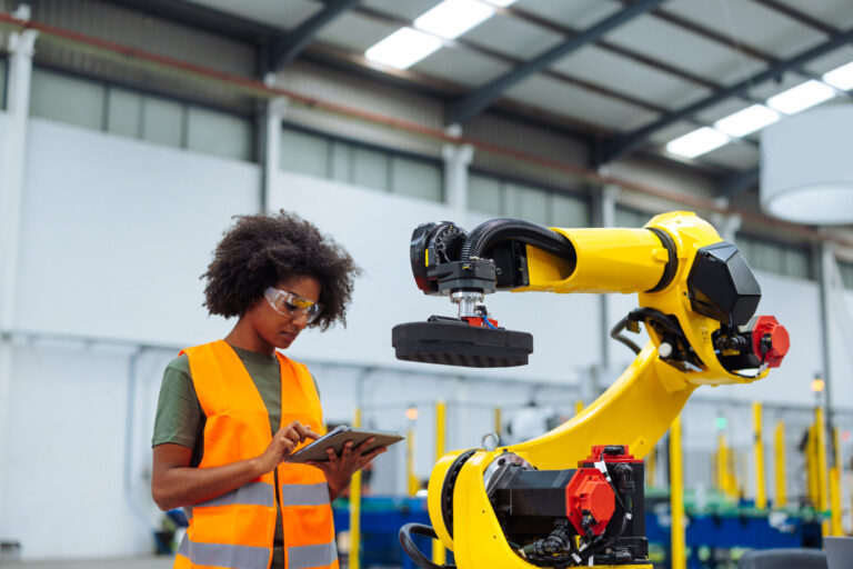 Technician operating an industrial robot arm