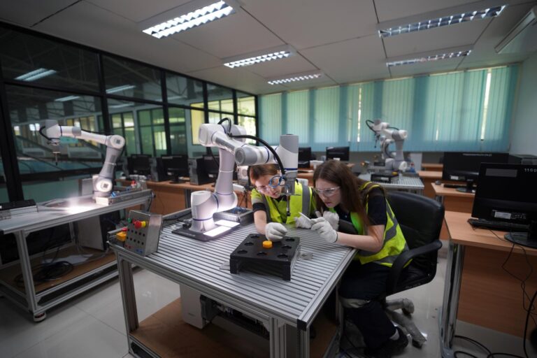 Students working with robotic arms in a lab