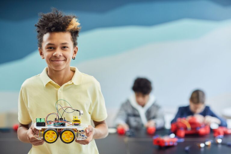 Young camper holding a robot car he built